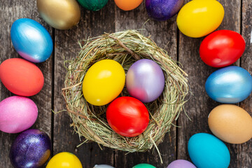 Fototapeta na wymiar multi colors painted easter eggs in nest. Happy Easter Card 