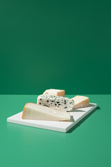 Surtido de quesos franceses. Queso de leche de cabra, vaca y oveja sobre un fondo verde. Vista...