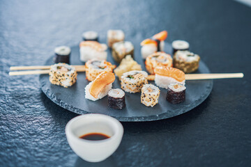 Stone plate with sushi on stone counter top