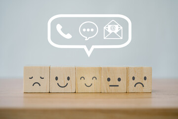 emoticon on wooden cube blocks with contact us sign above for happy smile face icon to give...