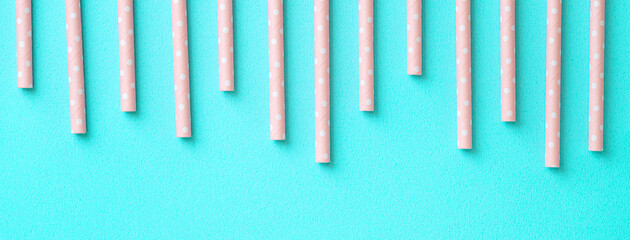 Biodegradable paper straw set on blue table background.