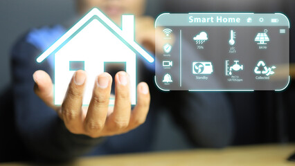 A man wearing a causal is holding the whole house in his hands. Controlling home appliances through...