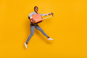 Full size profile side photo of young excited girl jump active journey vacation airport fly isolated over yellow color background