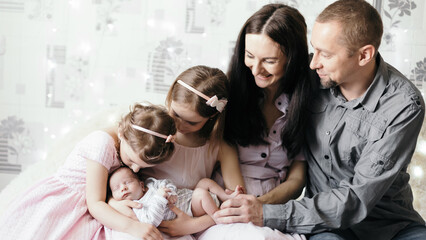 happy parents next to their three children .