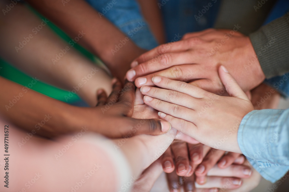 Poster teamwork will get it done. high angle shot of university students hands in a huddle.