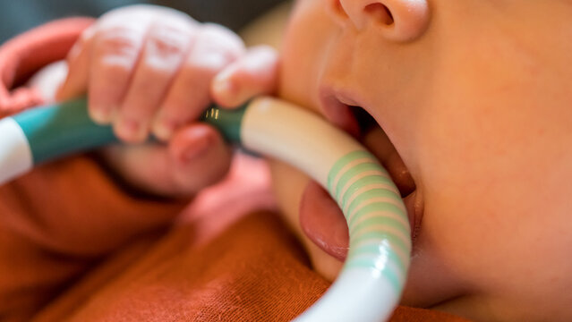 Detail of baby biting on a teething ring