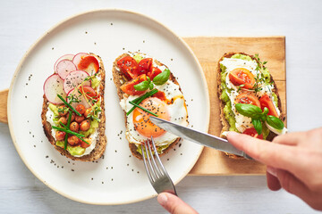 Vegetarian egg sandwiches on white background.. Healthy vegetarian sandwiches with egg tomatoes avocado cream and cheese garnished with chia seeds and aromatic herbs. Vegetarian sandwich.