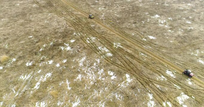 ATVs Go at a Speed on a Snow-covered Field. Mariel. Aerial View.Quadrotor Filming
