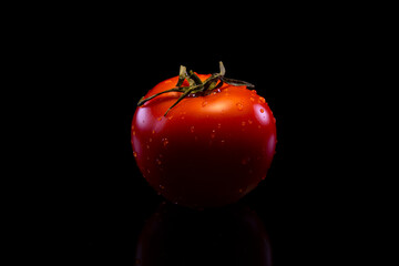 Red perfect tomato on a black background. Fresh, perfect and firm tomato