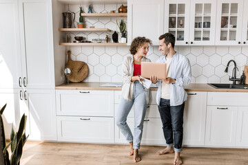 Stylish happy confident colleagues discussing a new project together in modern office, smiling. Successful business partners working on strategy for company, learning financial graphs, making report