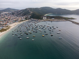 Anjos beach with many boats and houses in Arraial do Cabo, Rio de Janeiro, Brazil. Aerial drone view.