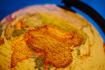 A table lamp in the form of a globe, a rotating globe of the earth on a blue background. Georgafia of the whole world. Close-up