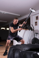 Tattooed man exercises in a gym. healthy training