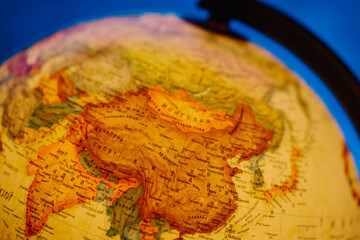 A table lamp in the form of a globe, a rotating globe of the earth on a blue background. Georgafia of the whole world. Close-up