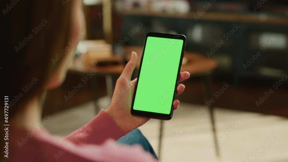 Leinwandbilder feminine hand scrolling feed on smartphone with green screen mock up display. female is resting at h