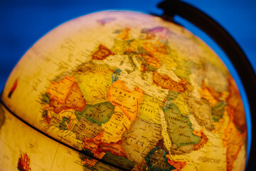 A table lamp in the form of a globe, a rotating globe of the earth on a blue background. Georgafia of the whole world. Close-up