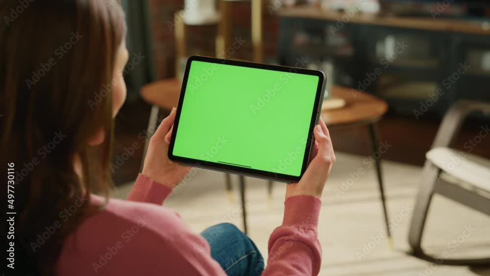 Poster young woman holding tablet computer with green screen mock up display. female resting at home, watch