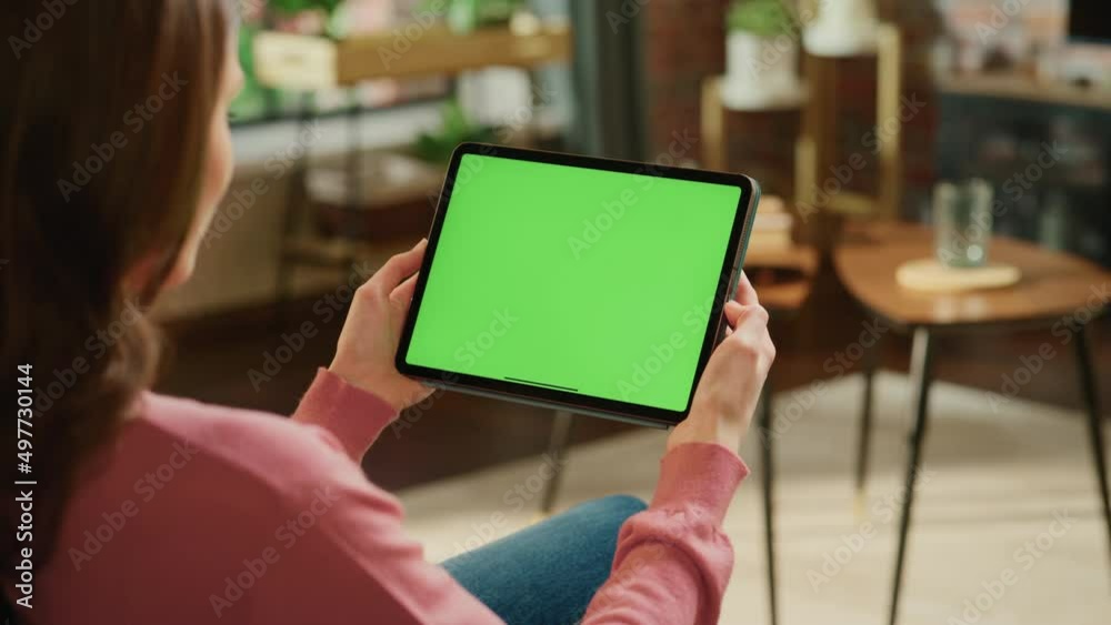 Leinwandbilder female scrolling content on tablet computer with green screen mock up display. woman relaxing at hom