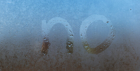 the word no handwritten on night wet window glass surface