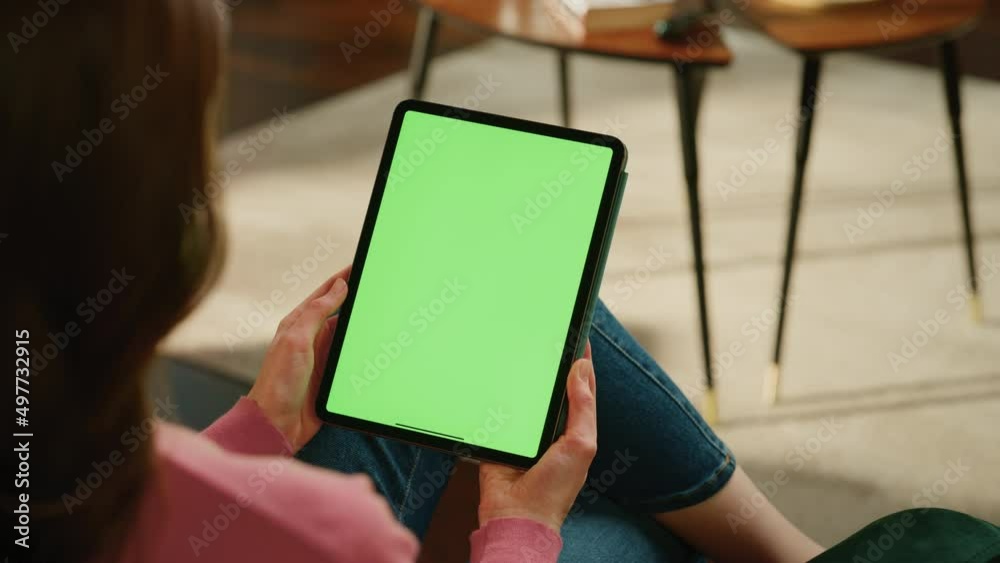 Poster Female Scrolling and Tapping on Content on Tablet Computer with Green Screen Mock Up Display. Woman Relaxing at Home, Reading Social Media Posts on Mobile Device. Close Up Over the Shoulder Footage.