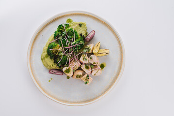 Dietary dish with chicken fillet with broccoli, broccoli puree, lime and onion on a white background