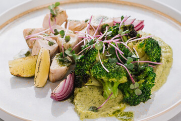 Dietary dish with chicken fillet with broccoli, broccoli puree, lime and onion on a white background