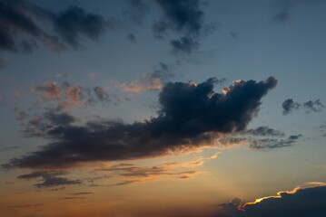 Russia. The South of Eastern Siberia. Gloomy sunset clouds in the evening summer sky over the mountain ranges of Eastern Sayan.