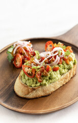 spicy chilli avocado guacamole on toast tapas on wood tray