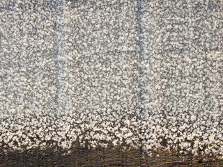 Snow ice texture. Thawed frost on a wooden board. wooden planks cowered with melting snow. Winter...