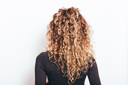 Back view of naturally curly hair young woman
