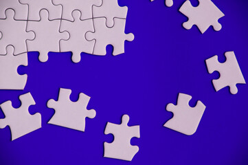 Top view of missing jigsaw puzzle on blue cover background. Copy space.