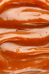 Liquid caramel syrup. Background of caramel paste. Texture Close up, top view.