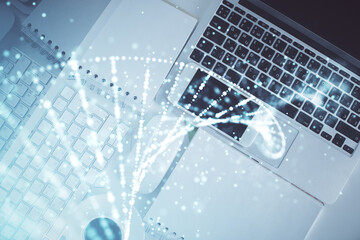 DNA hologram drawings over computer on the desktop background. Top view. Multi exposure. Concept medical education.