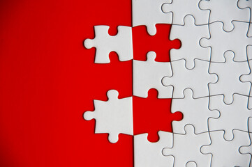 Fototapeta premium Top view of missing jigsaw puzzle on red cover background. Copy space