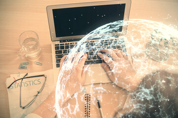 Double exposure of man's hands typing over computer keyboard and social network theme hologram drawing. Top view. People connection web concept.