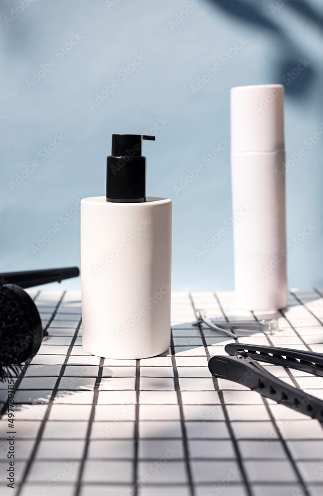 Wall mural hair care or styling white cosmetic bottle on the ceramic tile table . close up