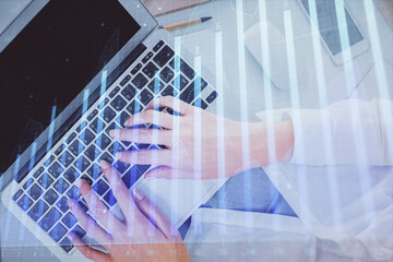Double exposure of woman hands working on computer and forex chart hologram drawing. Top View. Financial analysis concept.