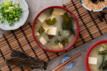 Delicious savory Japanese miso soup in a black bowl for eating.