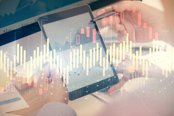 Double exposure of man's hands holding and using a phone and financial chart drawing. Market analysis concept.