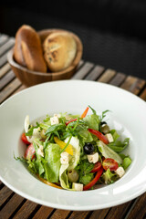 organic fresh greek salad with feta cheese on wood table