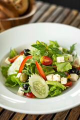 organic fresh greek salad with feta cheese on wood table