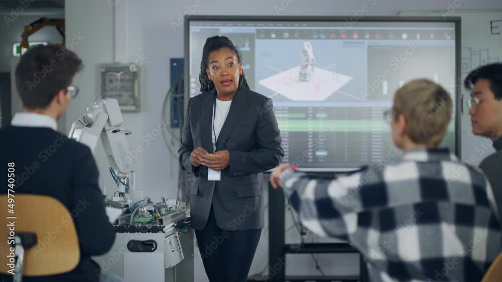 Poster Black Teacher Asking at Students Questions and Pointing at Robotic Hand while Explaining During Lesson. Smart Girl Showing with Hand at Robot. Engineering and Programming Language Concept. Slow Motion