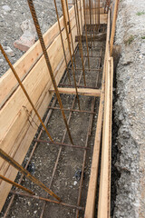 Obraz premium Reinforcement of the strip foundation, lower layer of reinforcement, unfinished formwork