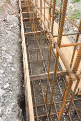 Reinforcement of the strip foundation with metal reinforcement in a trench with formwork