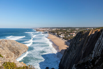 Praia Grande golden sand beach in the Sintra region huge cliffs rise up from the beach on the...