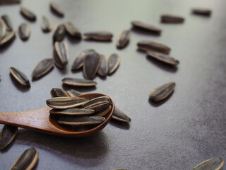Fototapeta na wymiar Sunflower seeds in wooden spoon on cement.