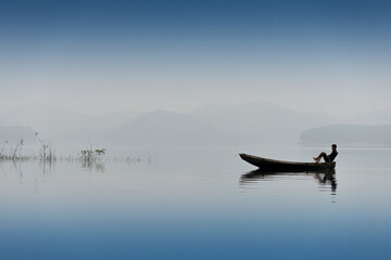 Zen . silhouette of a alone blue serenity fisherman in a lake of Vietnam  - peace dream and freedom