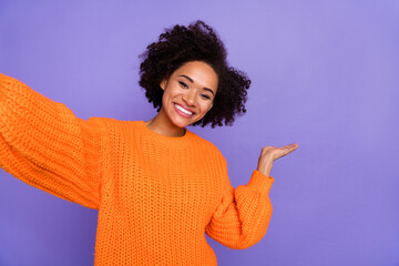 Self-portrait of attractive cheerful girl demonstrating copy space advert ad look isolated over bright purple violet color background