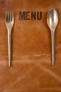 Menu Written On Brown Leather With Golden Spoon And Fork. Restaurant Menu Mockup