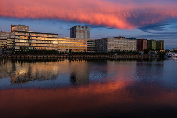 Fototapeta na wymiar View of modern buildings near the water during sunset